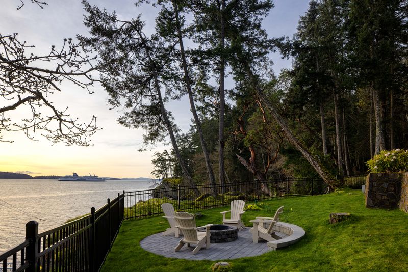 Lawn and fire pit above the water at BrightWoods, Fulford Harbour
