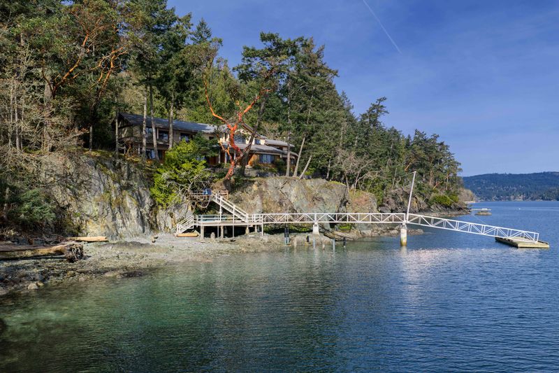 Shoreline and dock below the forest at BrightWoods, a Fulford Harbour waterfront property