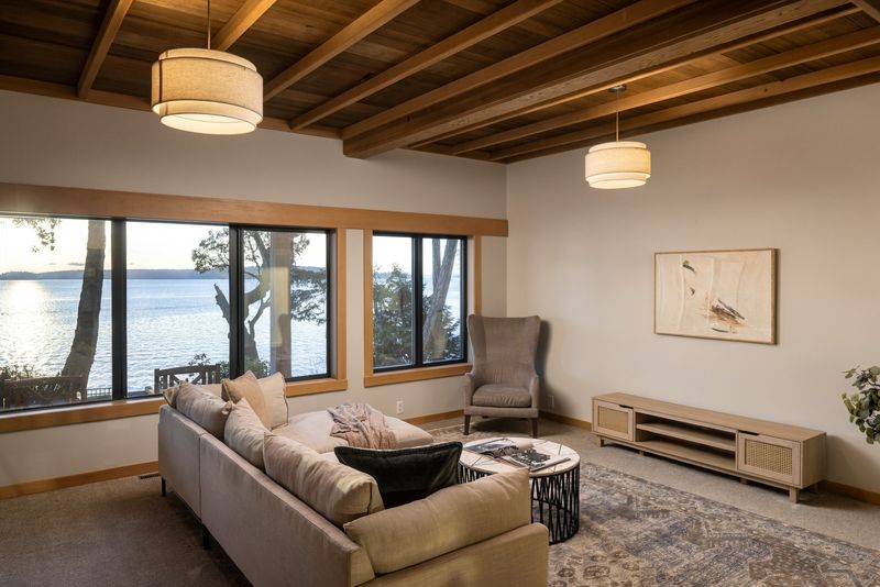 Sitting room at BrightWoods with timber ceiling and windows over the water